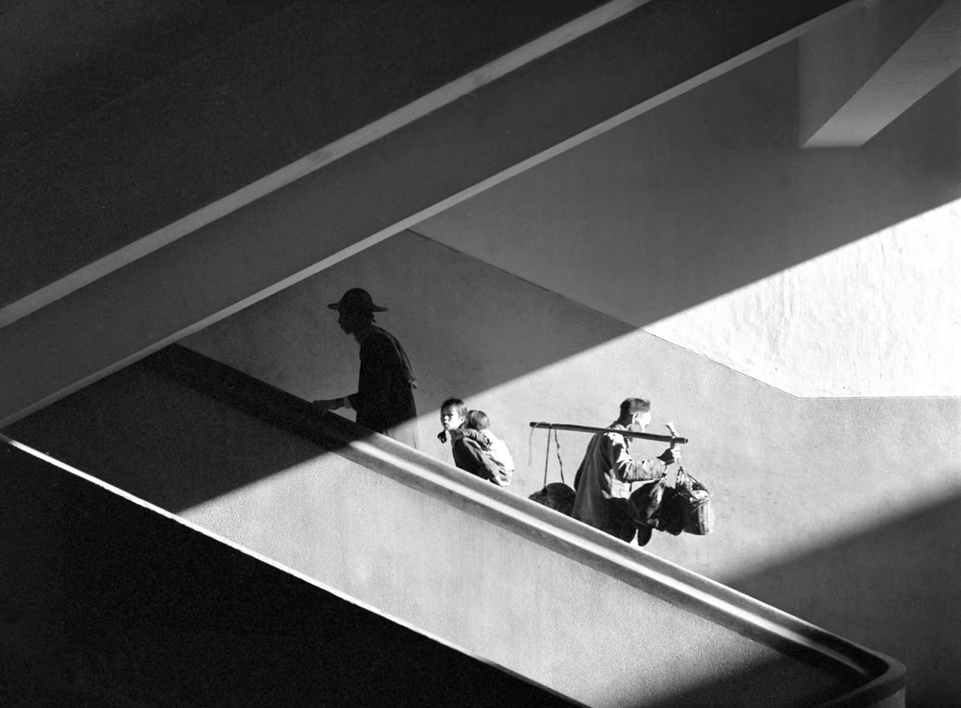 Sun Rays, de Fan Ho, 1959 — família em silhueta descendo uma escada, atravessada por feixes de luz